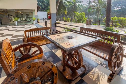 a wooden table and two benches with a table at Sterling Palavelli Godavari in Rāzole