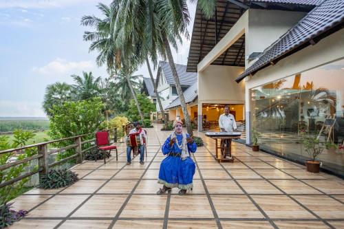 a woman in a blue dress standing on a porch at Sterling Palavelli Godavari in Rāzole