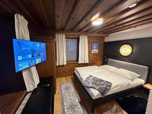 a bedroom with a bed and a flat screen tv at Kitzbühel City Appartement in Kitzbühel