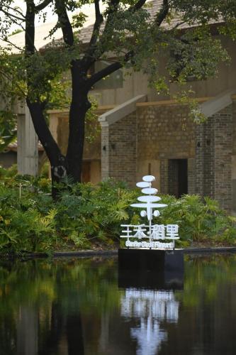 a pagoda in the water in front of a building at Sanhe Daoli Resort in Qingyuan