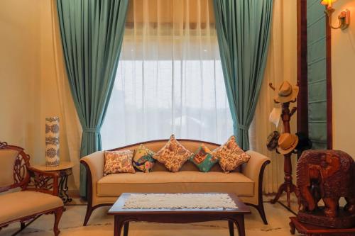 a living room with a couch in front of a window at Vanhills - Luxury Home Stay in Jim Corbett in Kota Bāgh