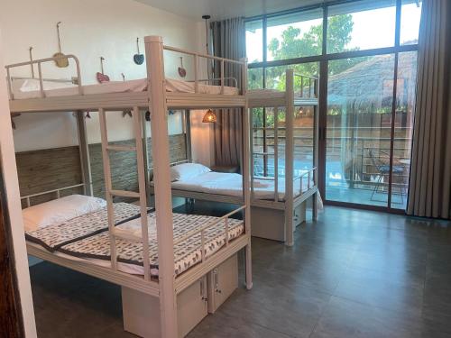 two bunk beds in a room with a balcony at 蓝色引力潜水度假村BLUE GRAVITY.WOW DIVING in Panglao