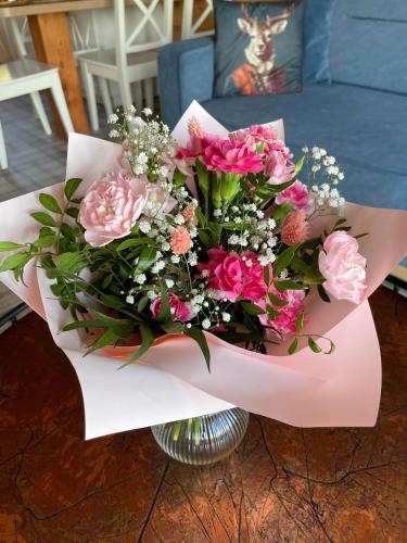 a bouquet of pink flowers in a vase at Wioska Jasia i Małgosi in Izdebnik