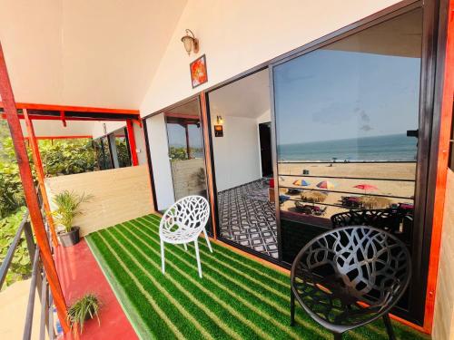 a room with a balcony with a view of the ocean at Casa Beach hut Resort in Palolem