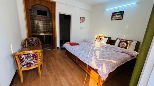 a bedroom with a bed and a chair in it at Mashobra Homestay - Crignano in Mashobra