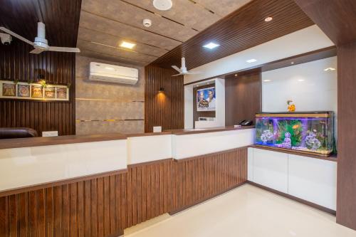 a bar with a fish tank in a room at Hotel PRM Aruna Archadia in Erode
