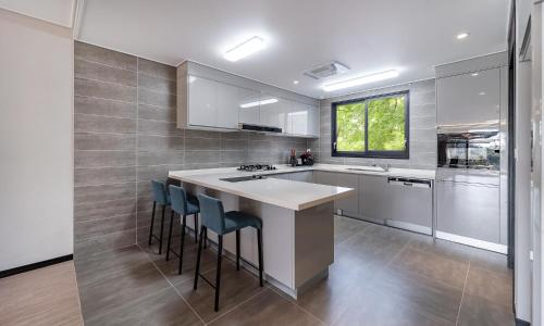 a kitchen with a counter and stools in it at Kylin Villa resort Jeju in Seogwipo
