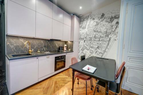 a kitchen with a table and a map on the wall at La Suite en Rose - Spa - Lyon Centre Brotteaux in Lyon