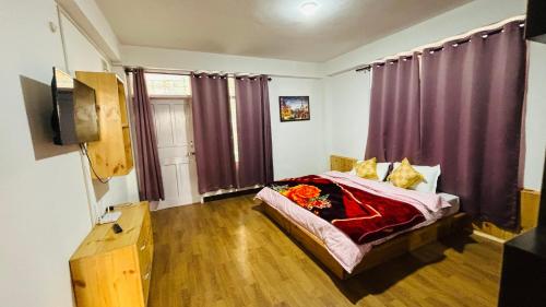 a bedroom with a bed with purple curtains at Mashobra Homestay - Crignano in Mashobra