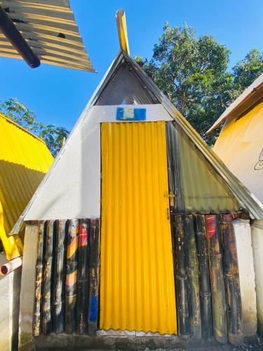 a yellow door on the side of a building at Gran Colibrí Adventure Park in San Pedro La Laguna