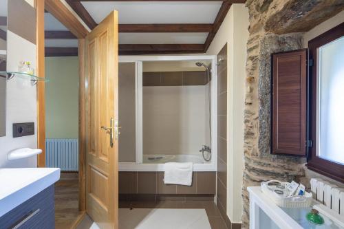 ein Badezimmer mit Dusche und Badewanne in der Unterkunft O forno do curro-Casiña Da Avelá in Boborás