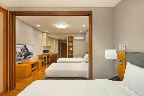 a hotel room with two beds and a kitchen at Somerset Palace Seoul in Seoul