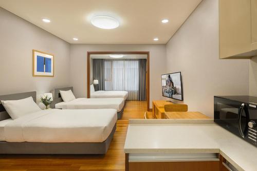 a hotel room with two beds and a television at Somerset Palace Seoul in Seoul
