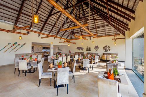 a restaurant with tables and chairs in a room at Sterling Palavelli Godavari in Rāzole