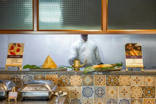 a chef standing behind a counter in a kitchen at Sterling Palavelli Godavari in Rāzole