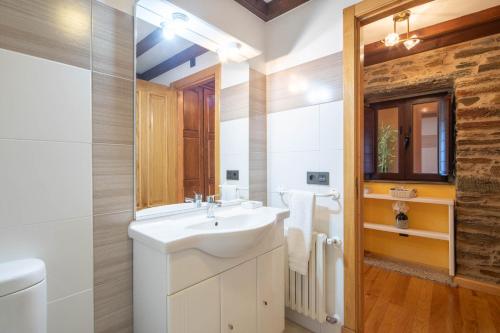 ein Badezimmer mit Waschbecken und Spiegel in der Unterkunft O Forno do Curro -Casa da Amendoa in Boborás