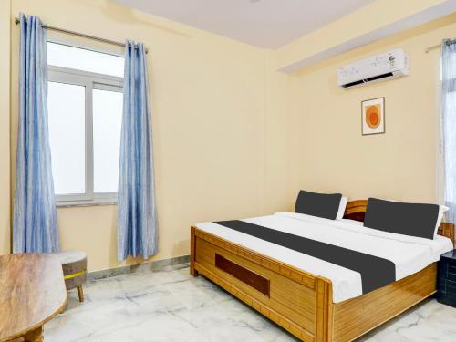 a bedroom with a bed and a window at Hotel O Mellow Space in Patna