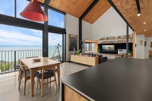 a kitchen and living room with a view of the ocean at Black Barn Escape in Nelson