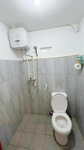 a bathroom with a toilet and a shower at Djuragan Kamar Halona in Ngemplak