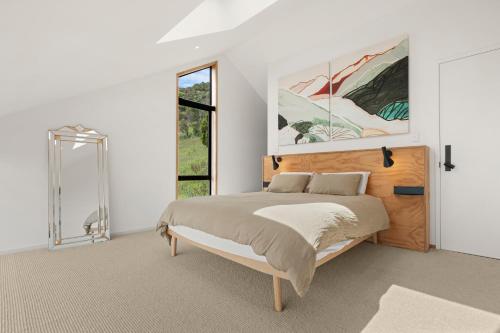 a bedroom with a bed and a large window at Black Barn Escape in Nelson