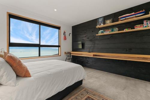 a bedroom with a large bed and a window at Black Barn Escape in Nelson