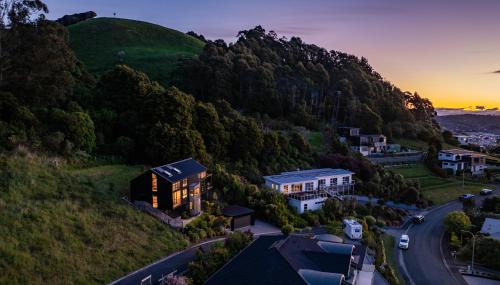 a house on a hill next to a road at Black Barn Escape in Nelson