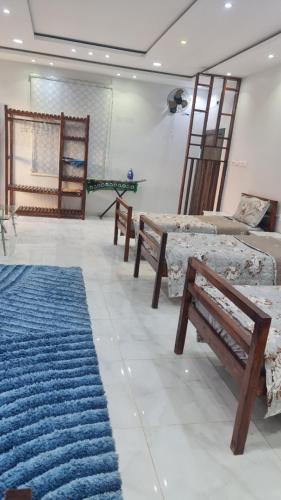 a living room with benches and a blue rug at Al Moltaqua Chalet in Taif