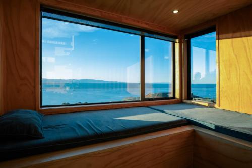 a window seat in a room with a view of the ocean at Black Barn Escape in Nelson