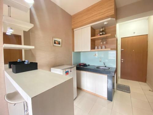 a kitchen with a counter and a sink in it at Cozy 2BR at Pinewood Apartment By Travelio in Sumedang