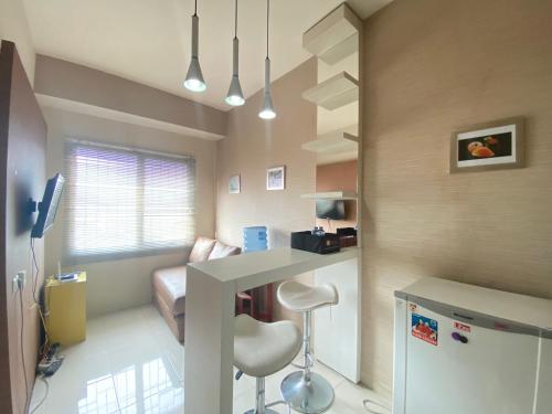 a room with a kitchen with a counter and a refrigerator at Cozy 2BR at Pinewood Apartment By Travelio in Sumedang