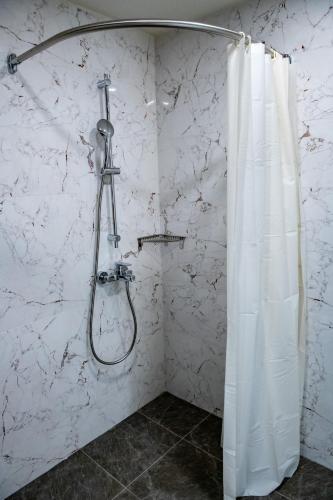 a shower with a shower curtain in a bathroom at BG Hotel in Sofia