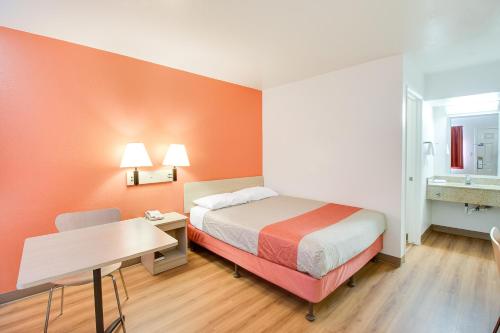 a hotel room with a bed and a desk and a sink at Motel 6-Phoenix, AZ - East in Phoenix