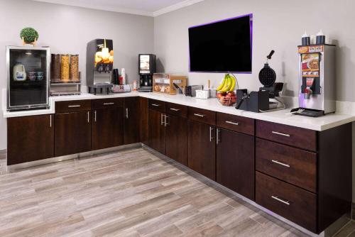 eine Küche mit Holzschränken und einem Flachbild-TV in der Unterkunft Super 8 by Wyndham Burnham/Lewistown in Burnham