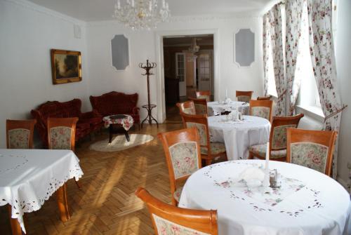 a dining room with white tables and chairs at Mazurski Dwór in Olecko