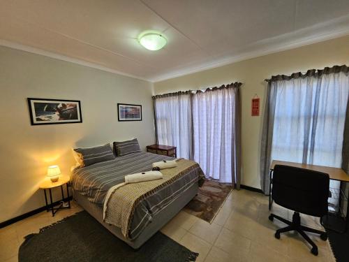 a bedroom with a bed and a desk and a television at Private Apartment in Port Alfred in Port Alfred