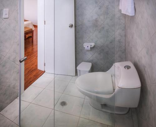 a bathroom with a toilet and a shower at Hotel Ajavi in Ibarra