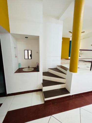 a staircase in a building with a yellow column at Stay Confo Villa in Puducherry