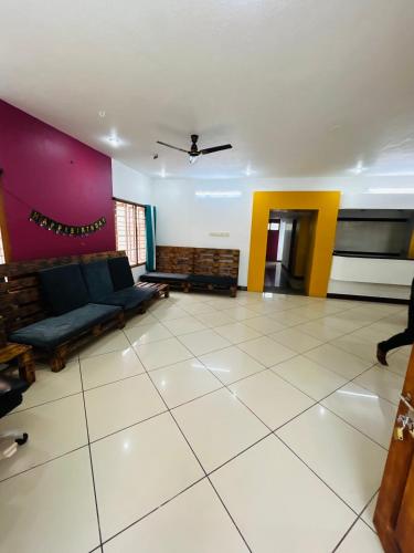 a living room with a couch and a purple wall at Stay Confo Villa in Puducherry