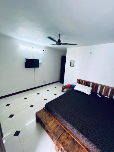 a bedroom with a bed and a flat screen tv at Stay Confo Villa in Puducherry