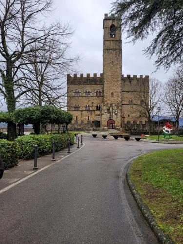 a large building with a clock tower on a street at Casa Fresia centro storico Poppi in Poppi