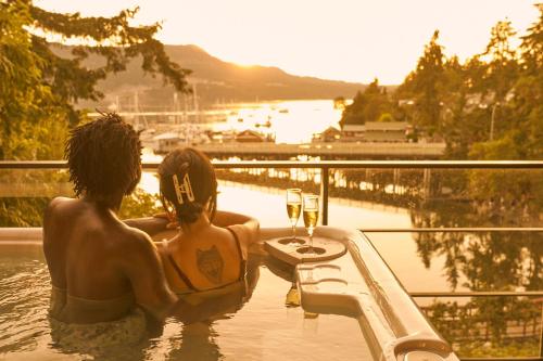 two people in a bath tub with a glass of wine at Brentwood Bay Resort & Spa in Brentwood Bay