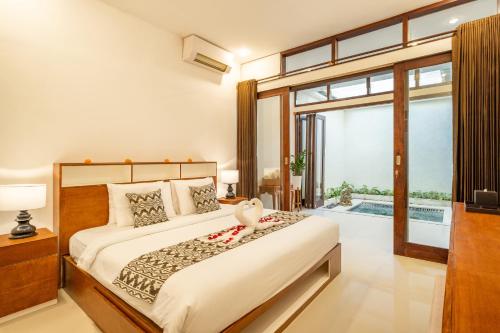 a bedroom with a bed and a large window at Seven Residence in Seminyak