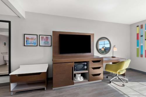 a room with a desk with a tv and a chair at Hampton Inn & Suites Phoenix/Gilbert in Gilbert