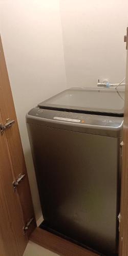 a black refrigerator in a room with a door at Matina Enclaves 2BR with Wifi Near SM Mall in Davao City