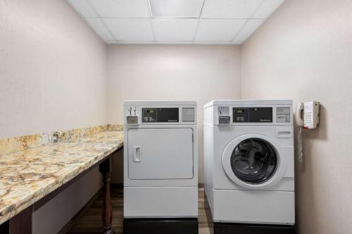 a laundry room with a washing machine and a phone at Hampton Inn & Suites Phoenix/Gilbert in Gilbert