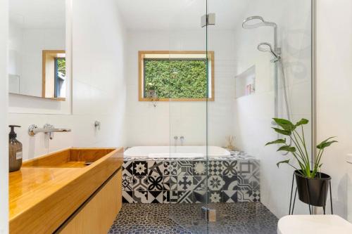 a bathroom with a tub and a sink and a shower at The Grass is Greener Getaway - Private Hot Tub in Whangamata