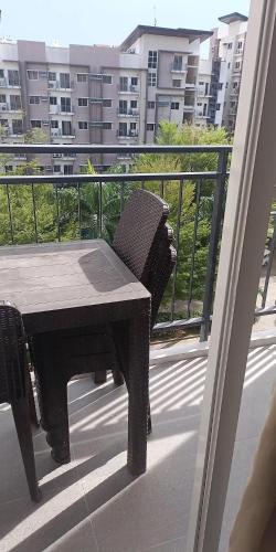 a table and chair on a balcony with a view of a building at Matina Enclaves 2BR with Wifi Near SM Mall in Davao City