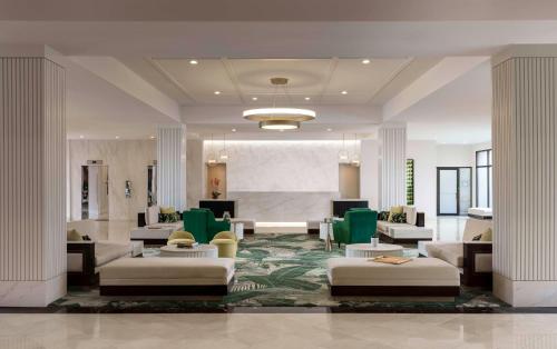 a lobby with couches and chairs in a building at Hilton Palm Beach PBI in West Palm Beach