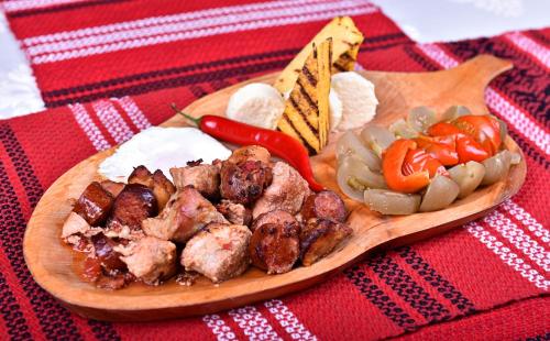 苏恰瓦Domeniul Haiducilor Bucovina的桌上有一盘有肉和蔬菜的食物