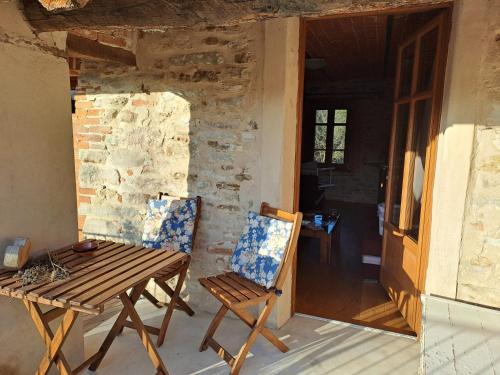 a wooden table and two chairs on a porch at Cascina Boschetto in Saliceto